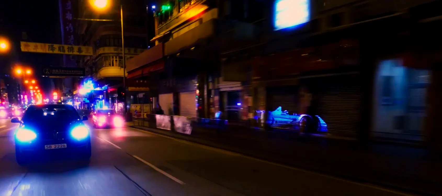 Night drive through a neon-lit city street for the BMW Formula E production