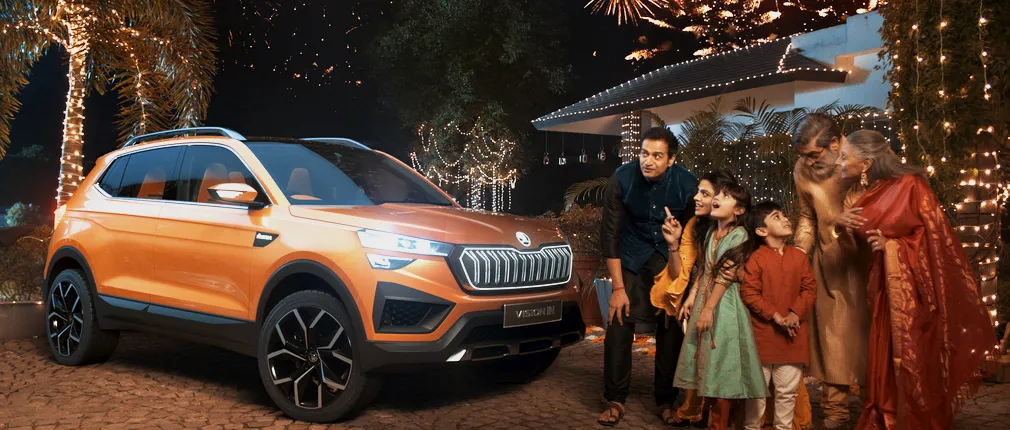 Indian family with sparklers on a festive night next to the Škoda Vision IN SUV