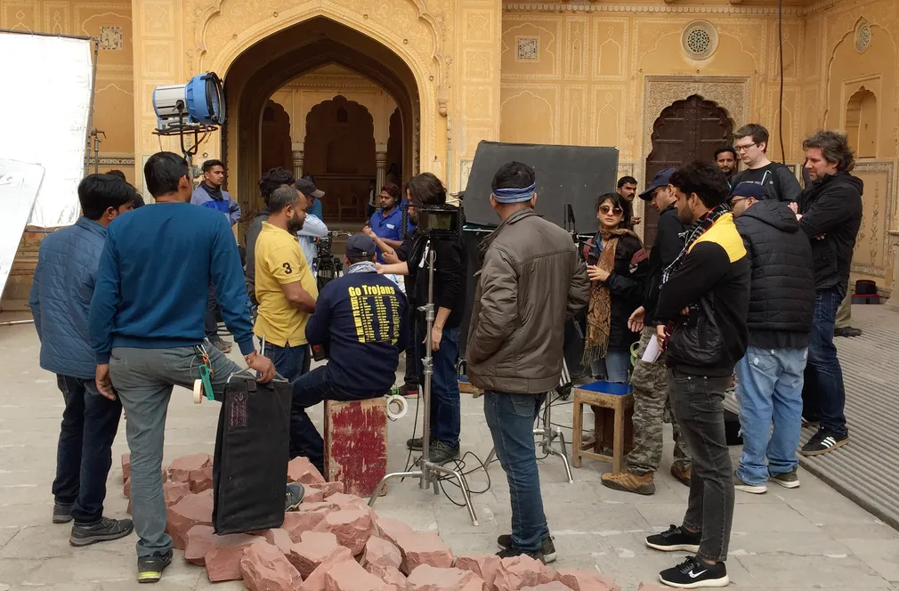 Large film crew gathered before a historic palace gate during the Škoda Vision IN shoot