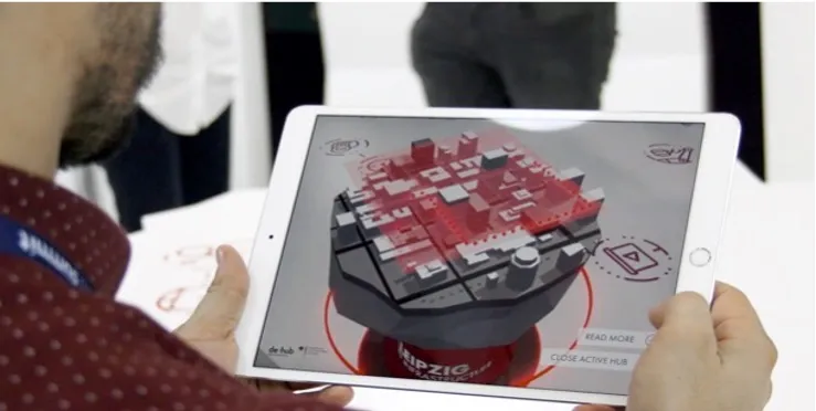Messebesucher betrachtet ein 3D-Stadtmodell als Augmented-Reality-Anwendung auf dem Tablet