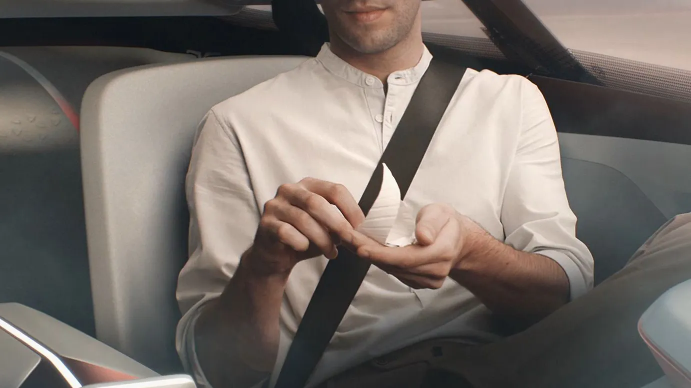 Belted passenger holding a glowing object inside the BMW Vision Next 100