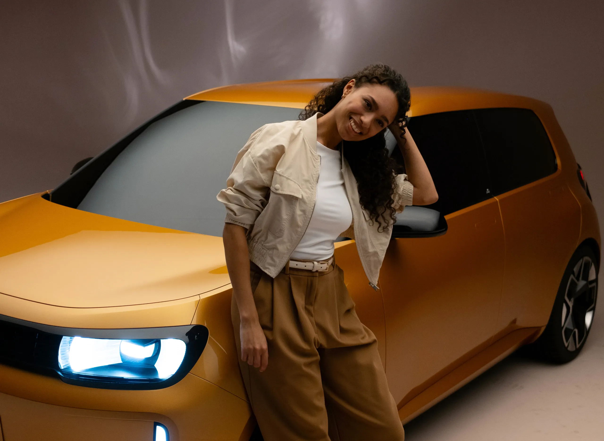 Laughing young woman leaning on the yellow ID. EVERY1, teaser for the Volkswagen social campaign