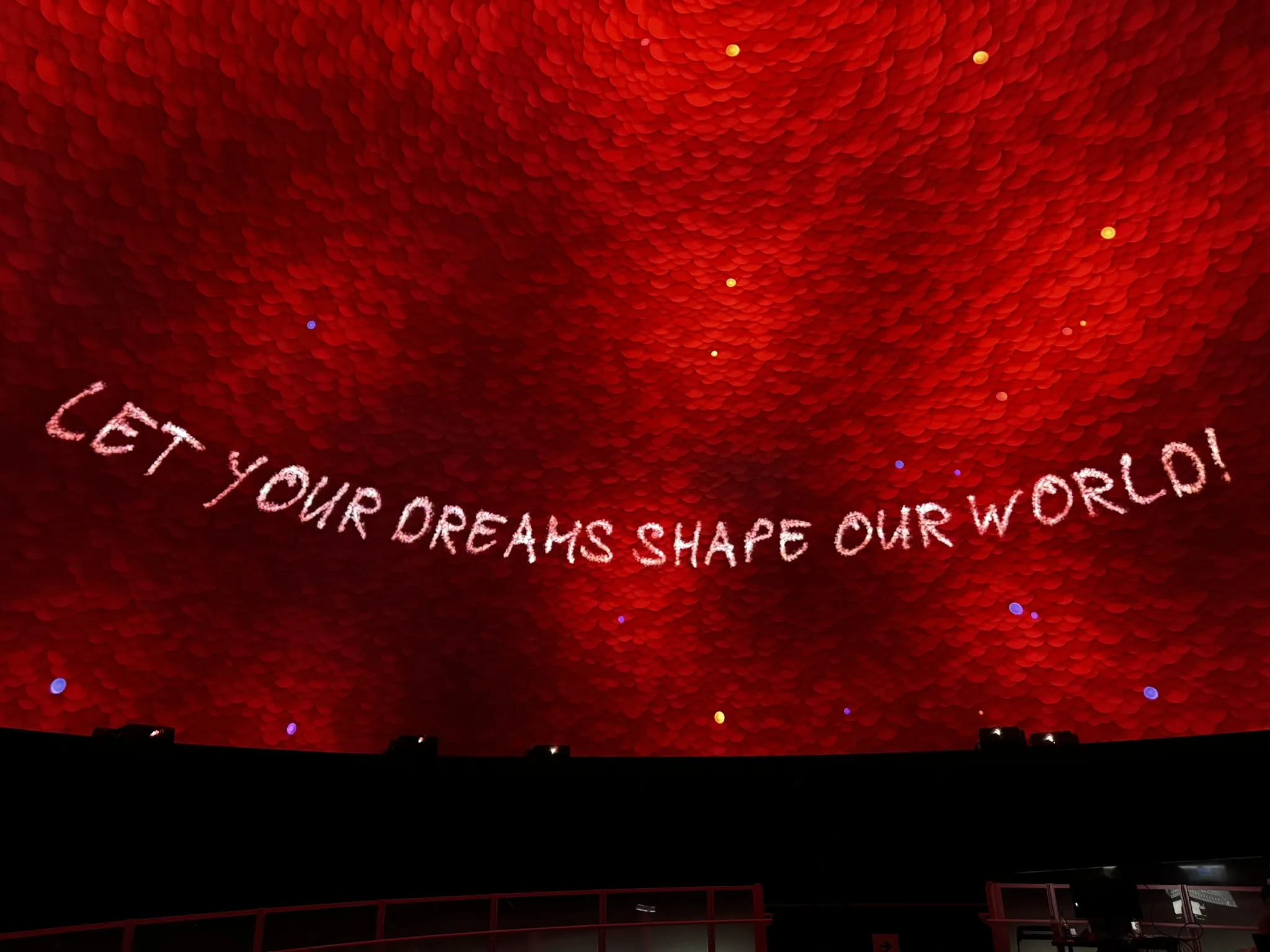 Red dome projection reading “Let your dreams shape our world!” in the EXPO 2025 Singapore Pavilion