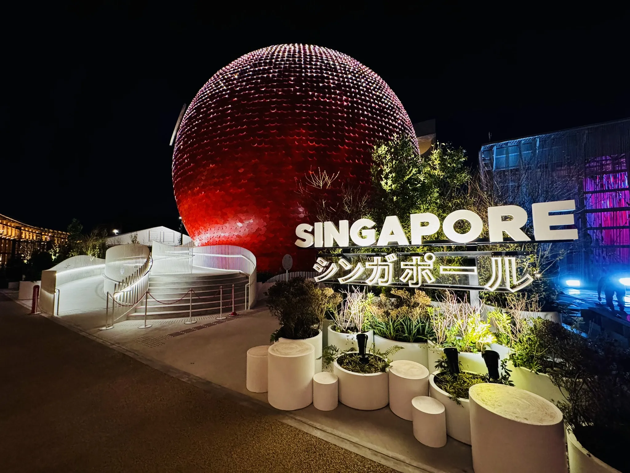 Red sphere lit up at night with “Singapore” lettering at the EXPO 2025 Singapore Pavilion