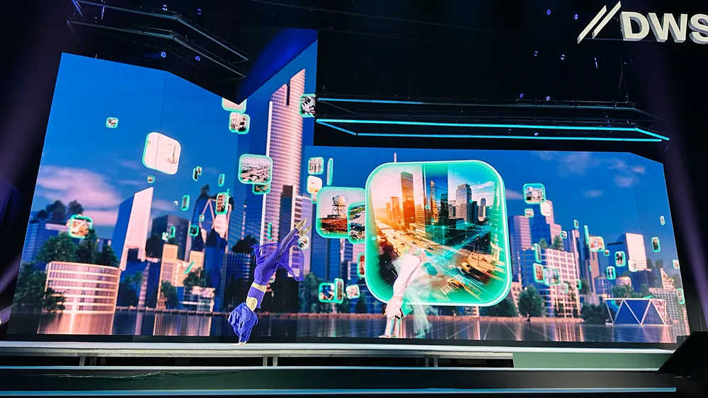 Dancers before an LED wall with city panorama and floating image tiles at the DWS conference