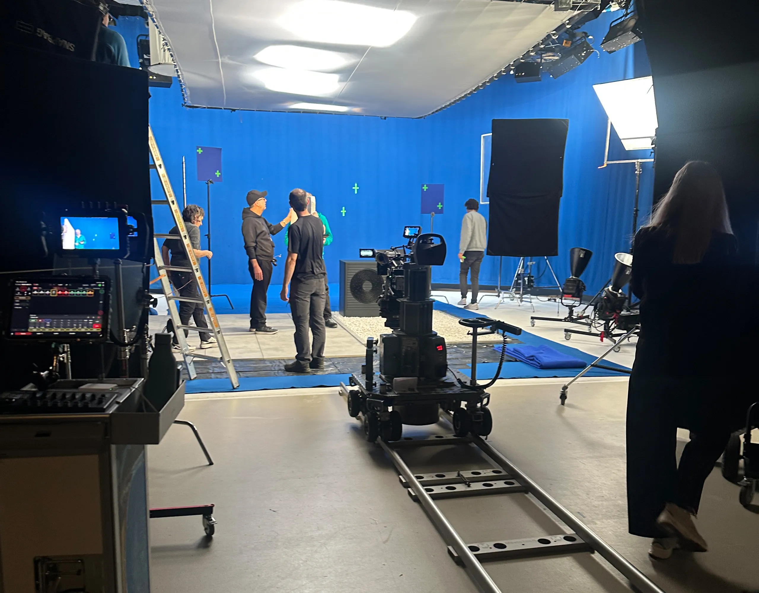 Film crew with a camera on dolly track before a blue screen for the Vaillant trailer